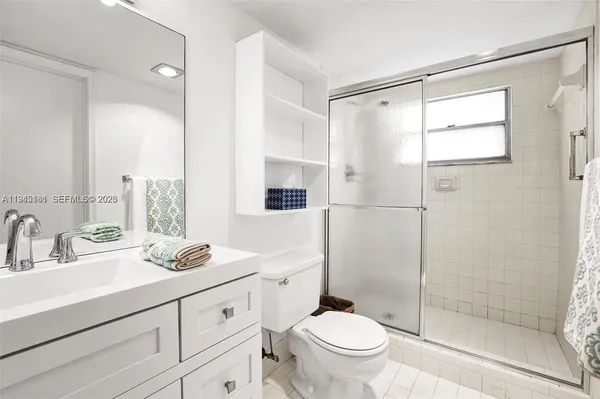 a bathroom with a double vanity sink toilet and shower