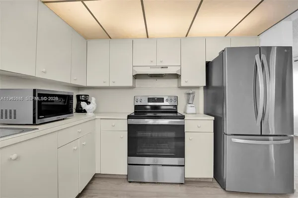 a kitchen with white cabinets and stainless steel appliances