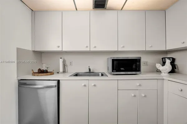a kitchen with granite countertop white cabinets and white appliances