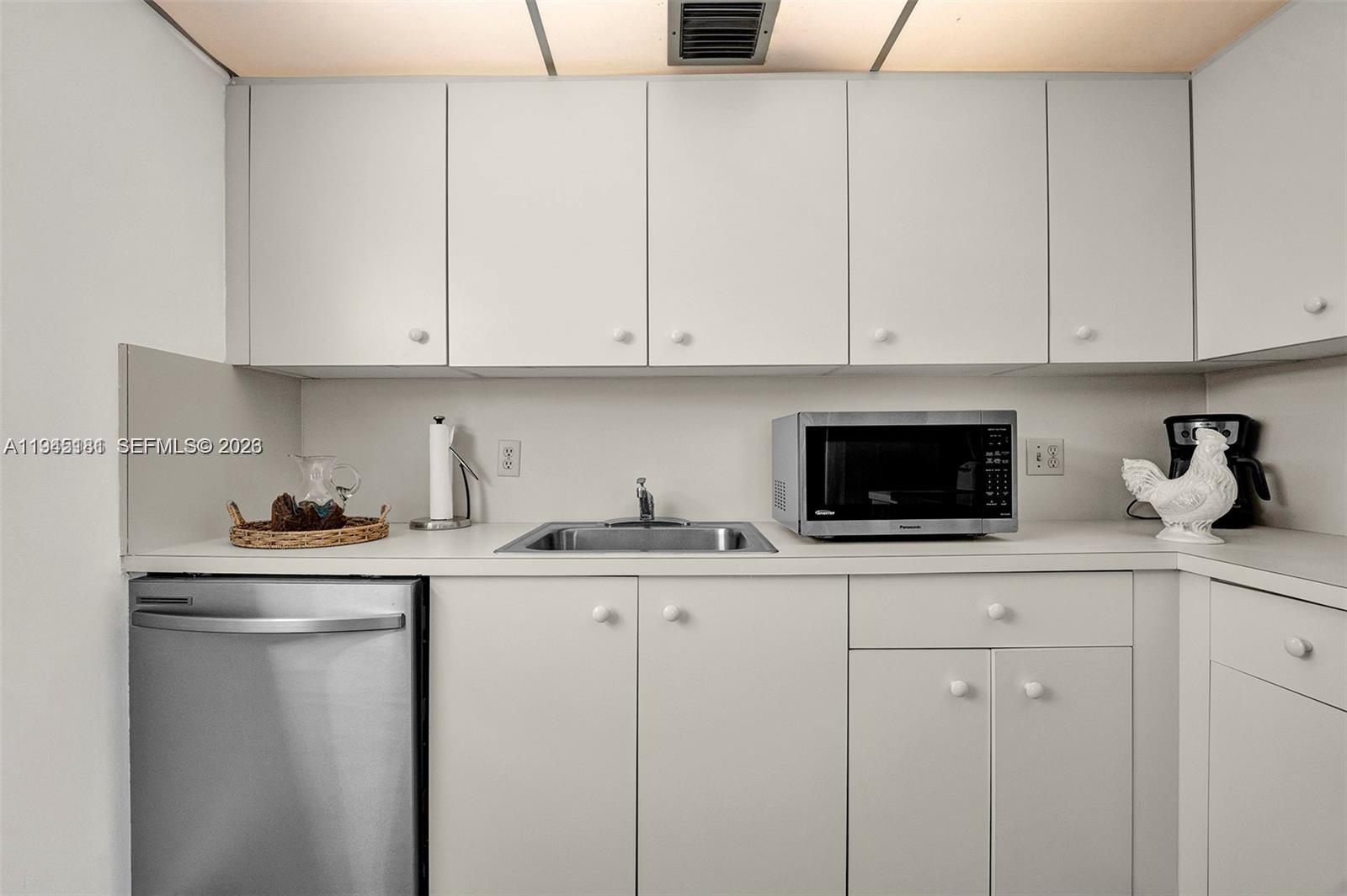 400 Southwest 134th Way, Unit 201F Pembroke Pines, FL 33027 - Photo 10 of 28 a kitchen with granite countertop white cabinets and white appliances