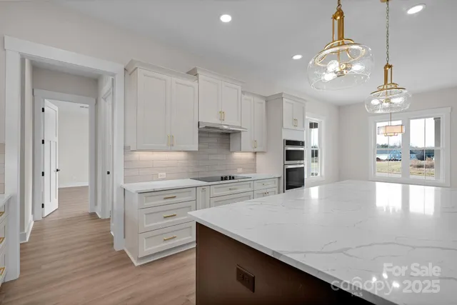a kitchen with stainless steel appliances granite countertop a stove refrigerator and cabinets