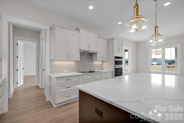 a kitchen with stainless steel appliances granite countertop a stove refrigerator and cabinets