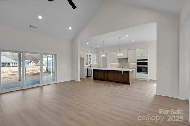 a view of kitchen with kitchen island and stainless steel appliances