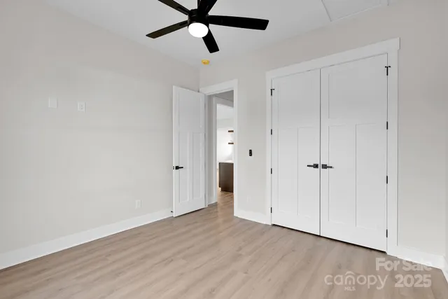 a view of a room with wooden floor and white walls