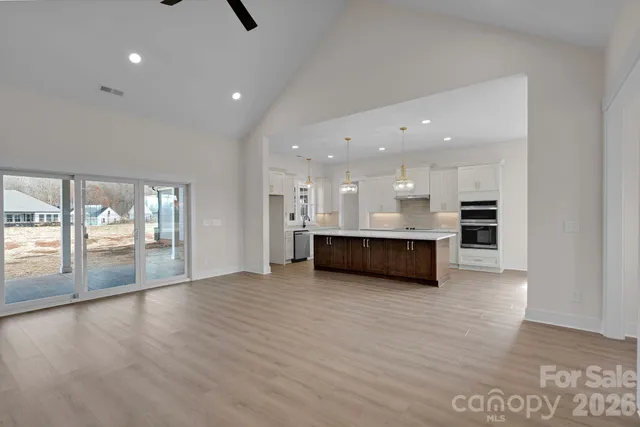 a view of kitchen with kitchen island and stainless steel appliances