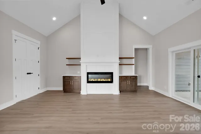 an empty room with wooden floor and fireplace