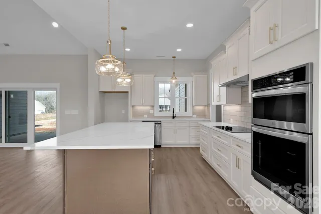 a large kitchen with granite countertop a stove and a sink
