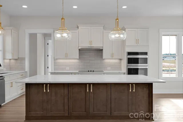 a view of kitchen with granite countertop cabinets and window