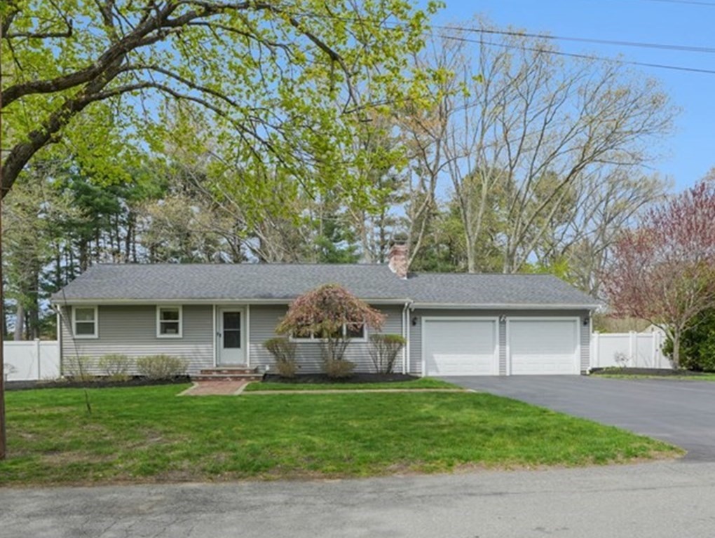 a front view of a house with a garden and trees