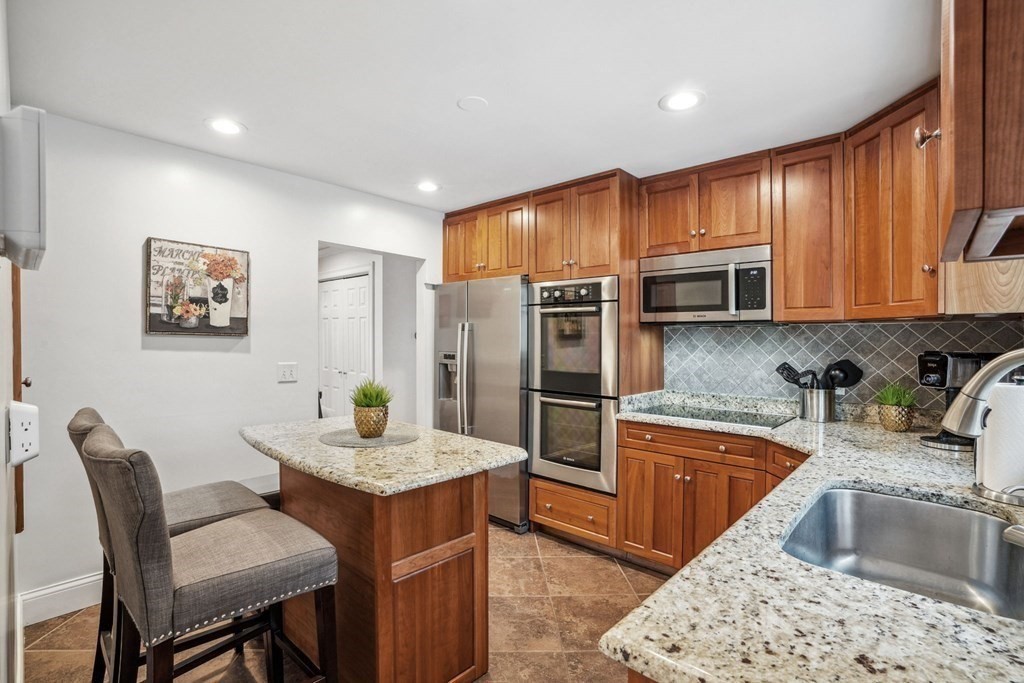 32 Red Barn Road Wayland, MA 01778 - Photo 9 of 27 a kitchen with stainless steel appliances granite countertop a kitchen island hardwood floor sink and stove