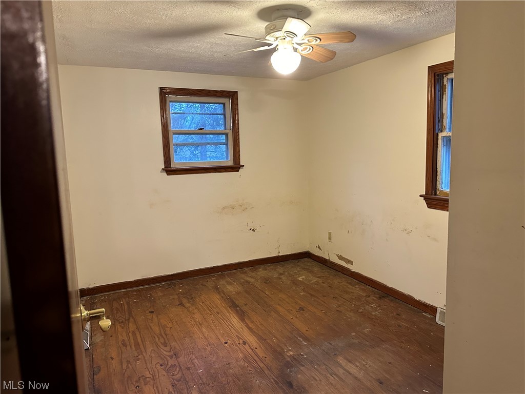 16055 Old State Road Middlefield, OH 44062 - Photo 8 of 12 Unfurnished room with ceiling fan, a textured ceiling, and dark wood-style flooring