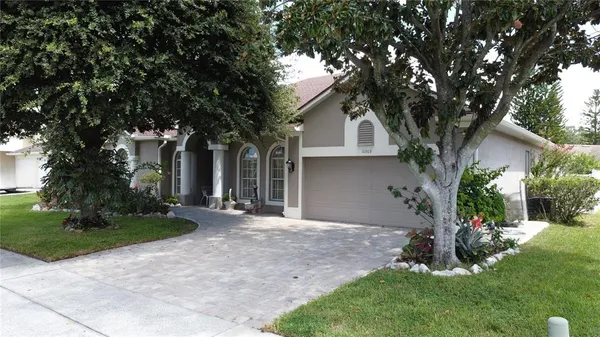 a front view of a house with a yard and tree