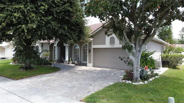 a front view of a house with a yard and tree