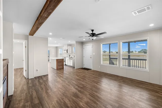 a view of a kitchen with wooden floor and a window
