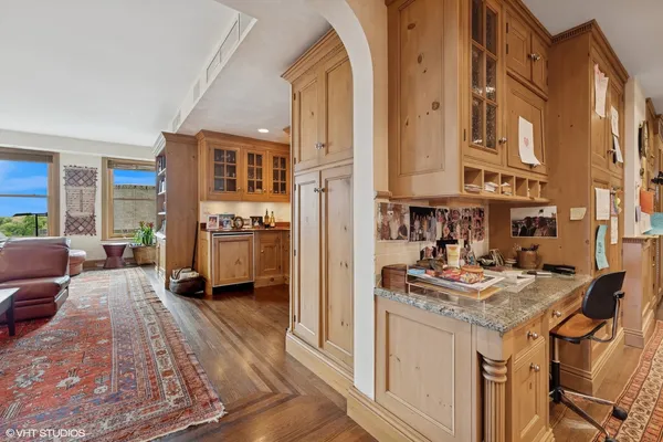 a living room with stainless steel appliances granite countertop furniture and a wooden floor