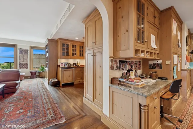 a living room with stainless steel appliances granite countertop furniture and a wooden floor