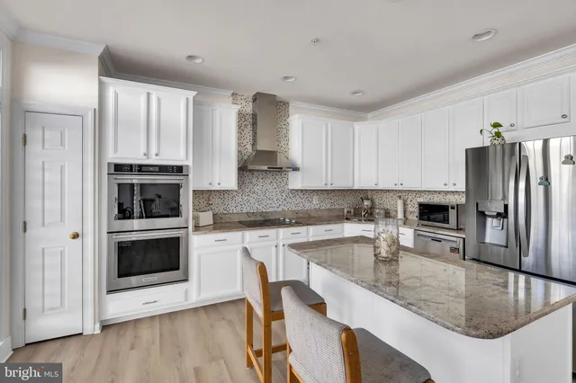 a kitchen with granite countertop a stove a sink and a refrigerator
