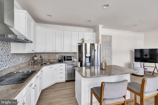 a kitchen with stainless steel appliances granite countertop a sink a stove top oven a counter space and cabinets