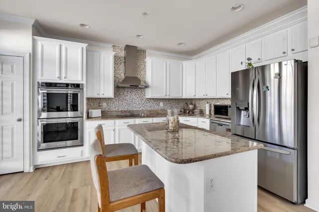 a kitchen with granite countertop a refrigerator stove and sink