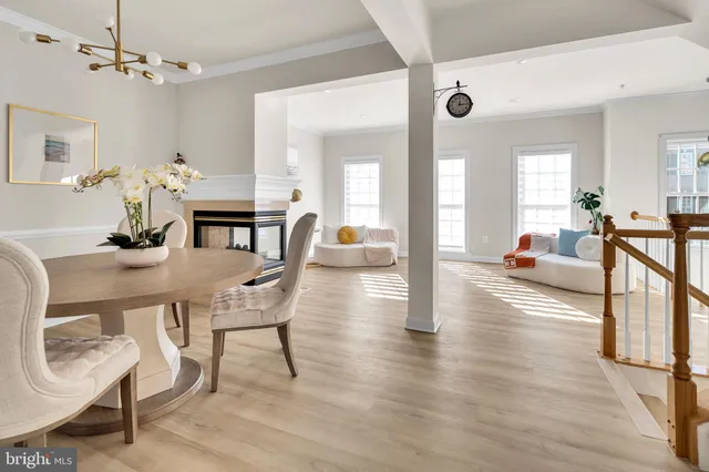 a dining room with furniture potted plants and wooden floor