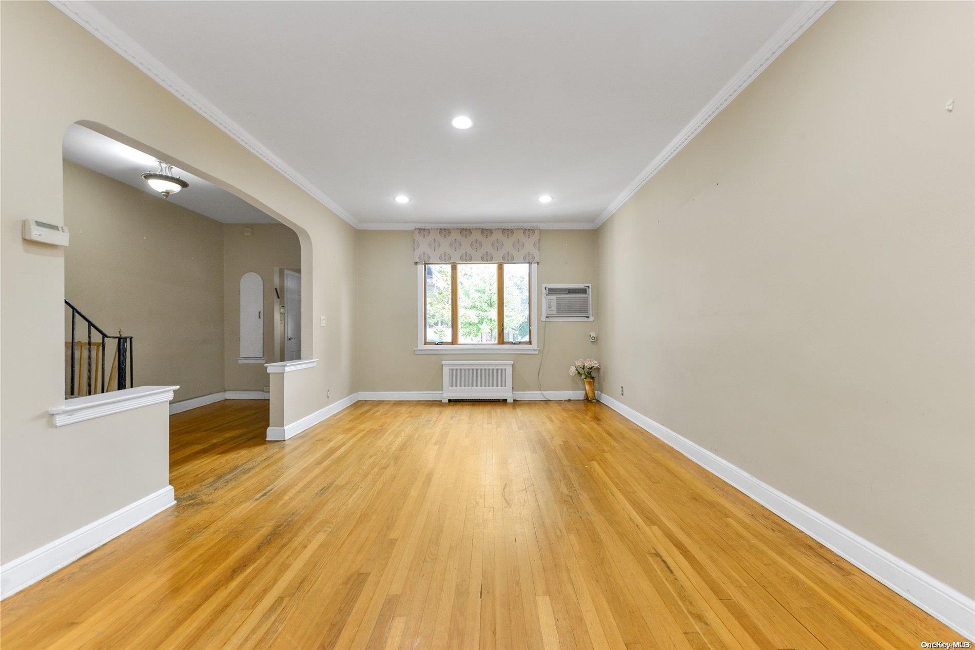 144-31 69th Road Queens, NY 11367 - Photo 2 of 21 wooden floor in an empty room with a window