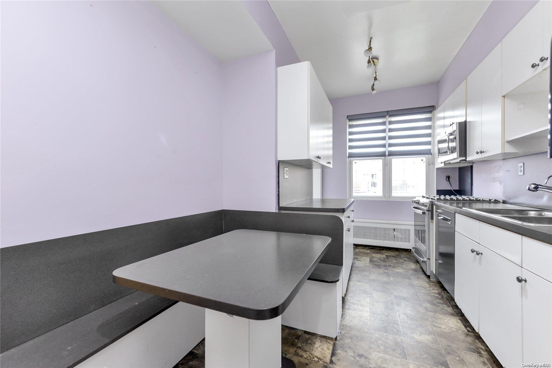 144-31 69th Road Queens, NY 11367 - Photo 8 of 21 a kitchen with a table chairs stove and cabinets