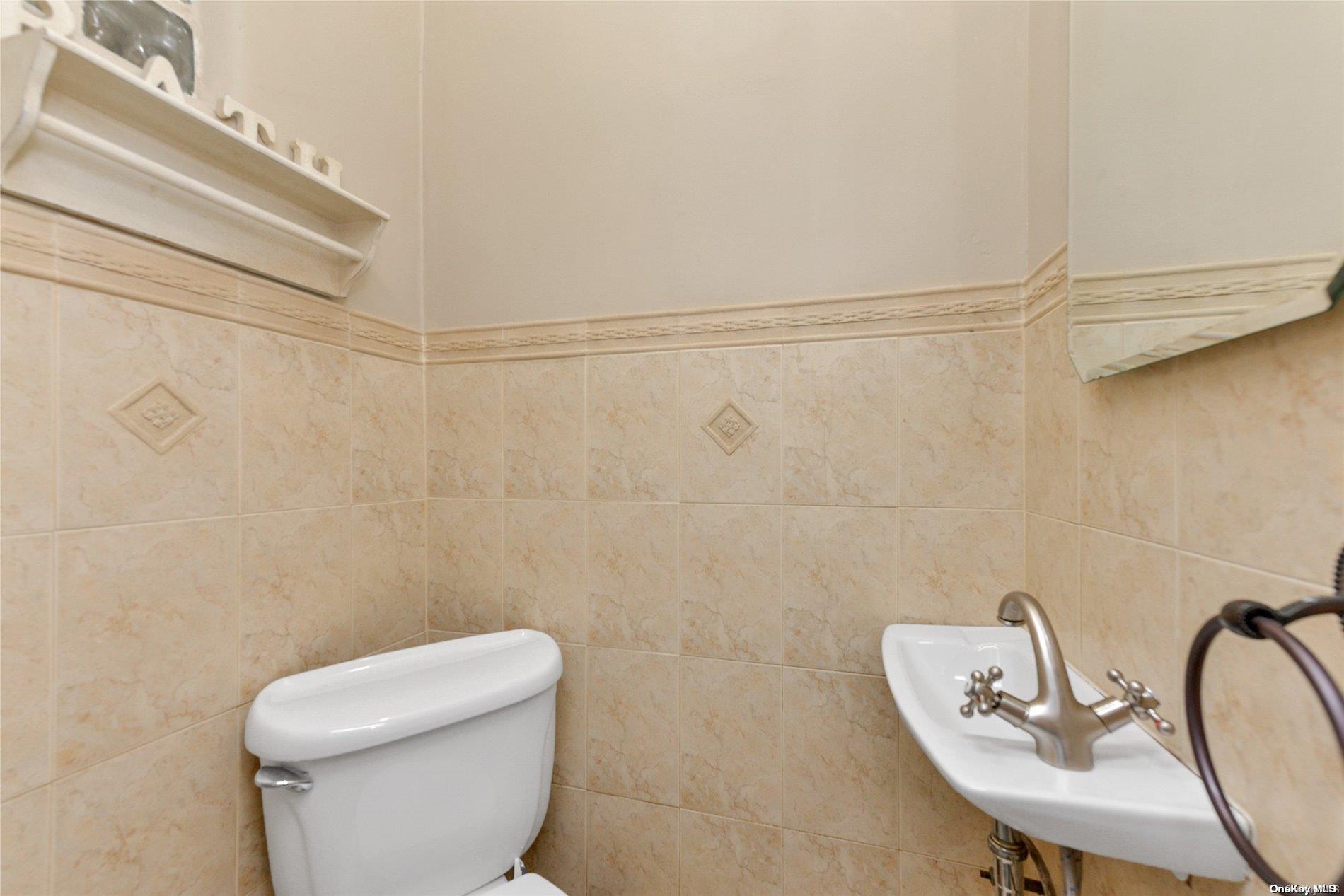 144-31 69th Road Queens, NY 11367 - Photo 10 of 21 a bathroom with a sink mirror and toilet