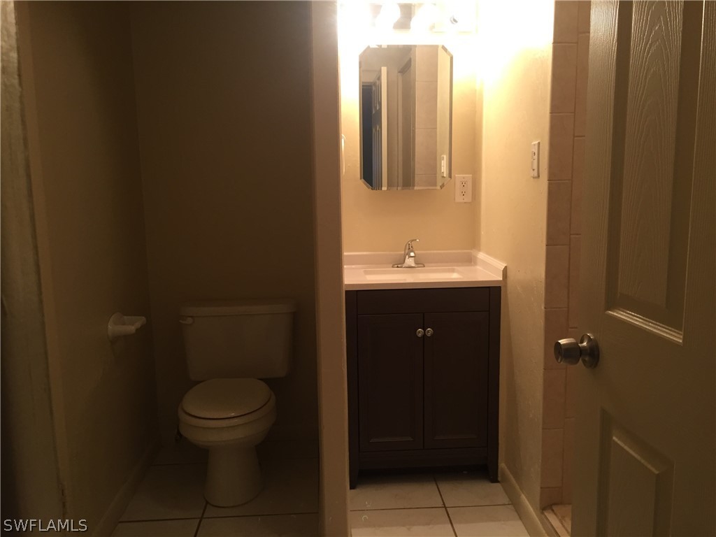 1545 Ransom Street Fort Myers, FL 33901 - Photo 23 of 25 a bathroom with a toilet a sink and mirror