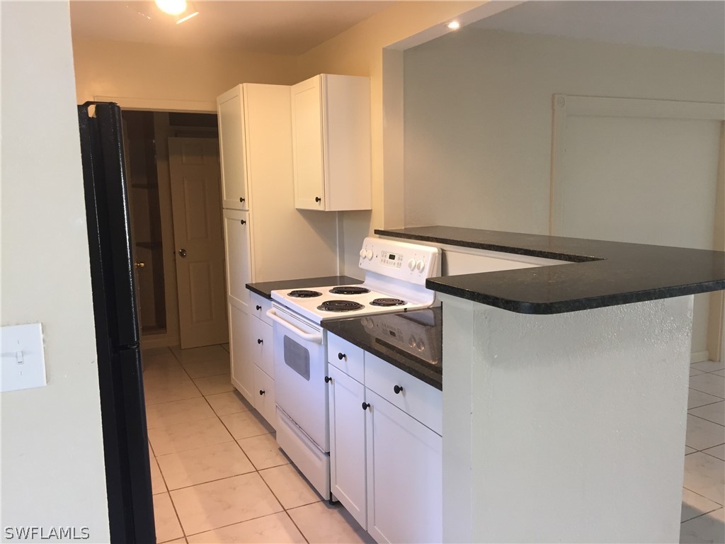 1545 Ransom Street Fort Myers, FL 33901 - Photo 7 of 25 a kitchen with stainless steel appliances granite countertop a refrigerator and a stove