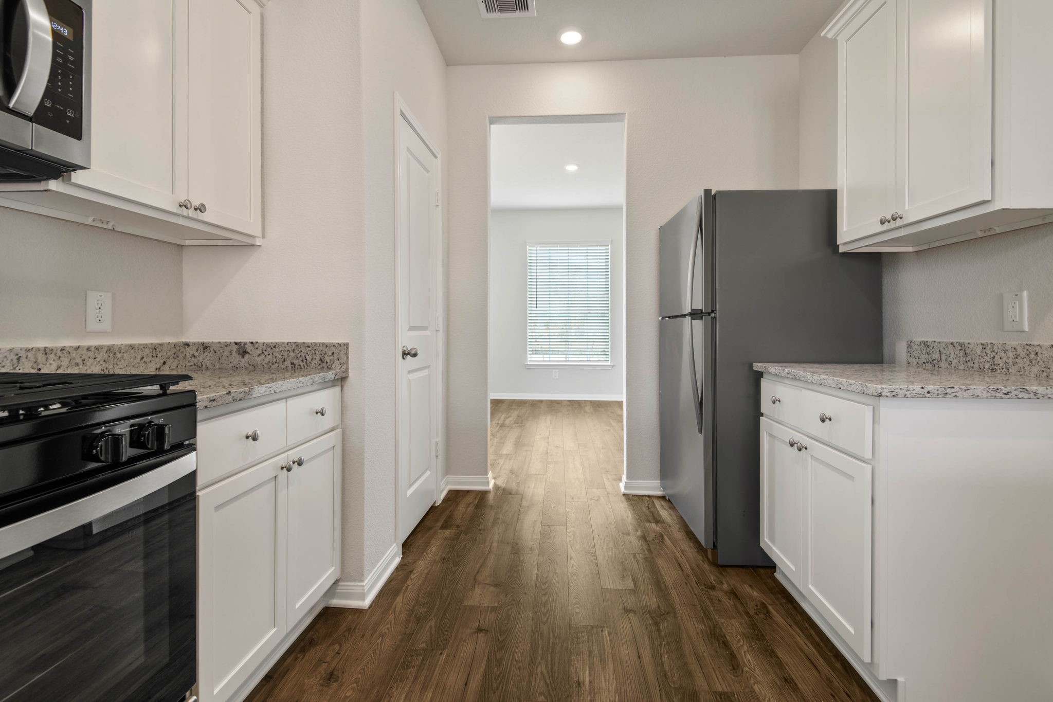 708 Jasmine Ridge Lane Waller, TX 77484 - Photo 7 of 12 a kitchen with cabinets appliances and a wooden floor