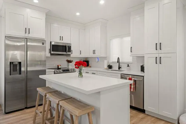 a kitchen with stainless steel appliances a stove refrigerator sink and cabinets