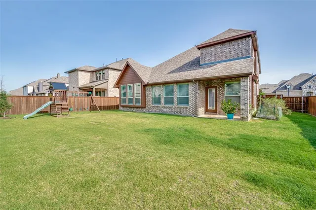a view of a house with a big yard and large trees