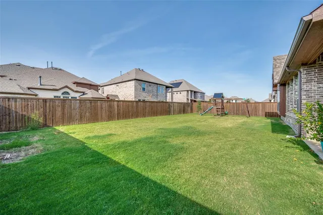 a view of a house with a big yard and wooden fence