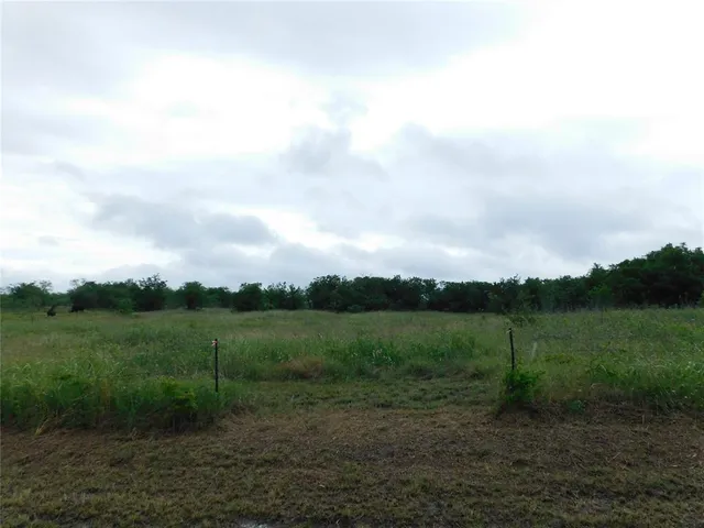a view of a field with a wooden fence