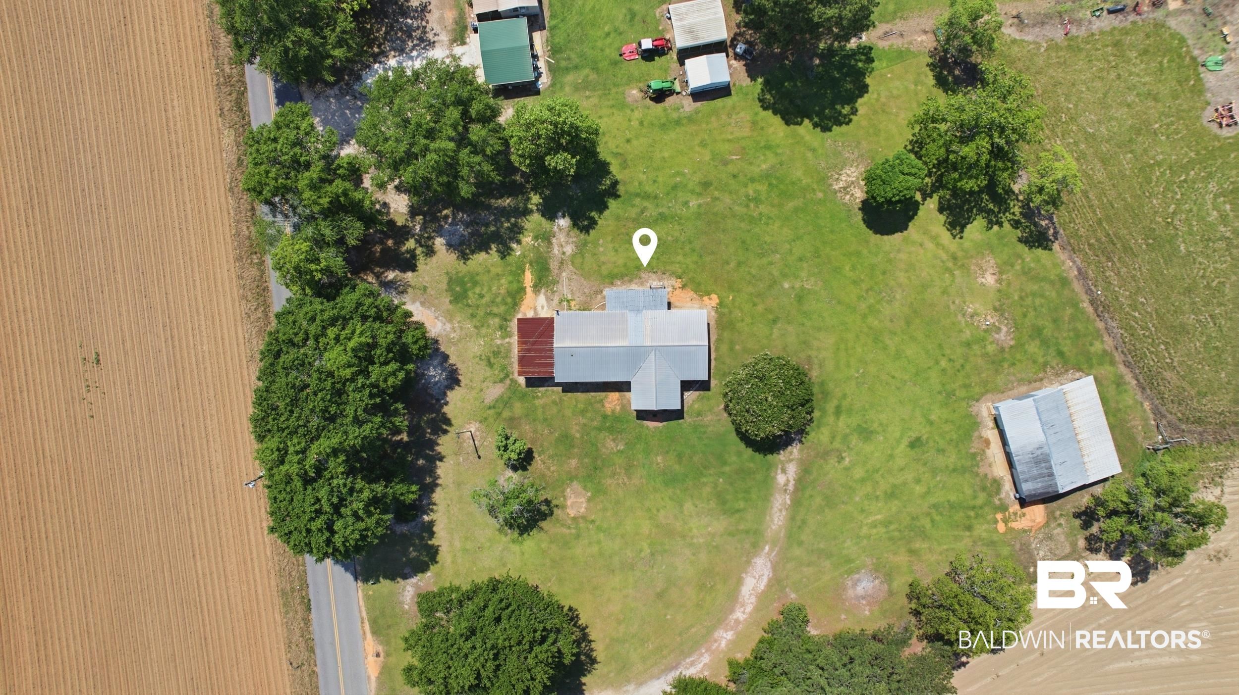 926 Tumbling Lane Atmore, AL 36502 - Photo 48 of 56 Rural property featuring a main residence with a metal roof, surrounded by expansive green space