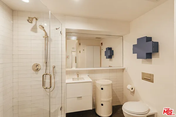 a bathroom with a toilet sink shower and mirror