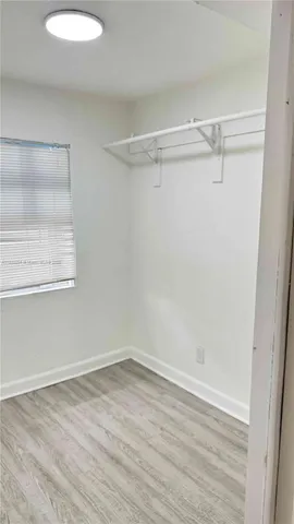 a view of a room with wooden floor and fan