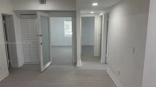 a view of a hallway with closet and wooden floor
