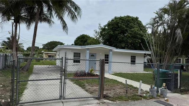 front view of house with a yard and potted plants