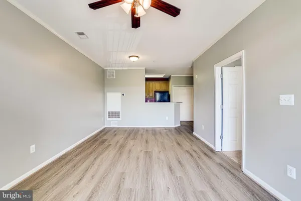 a view of empty room with wooden floor and ceiling fan
