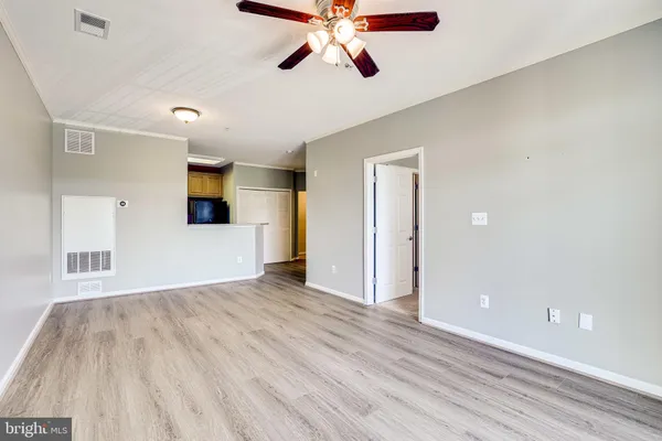 an empty room with wooden floor and mirror