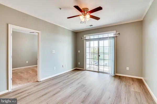 an empty room with window and ceiling fan
