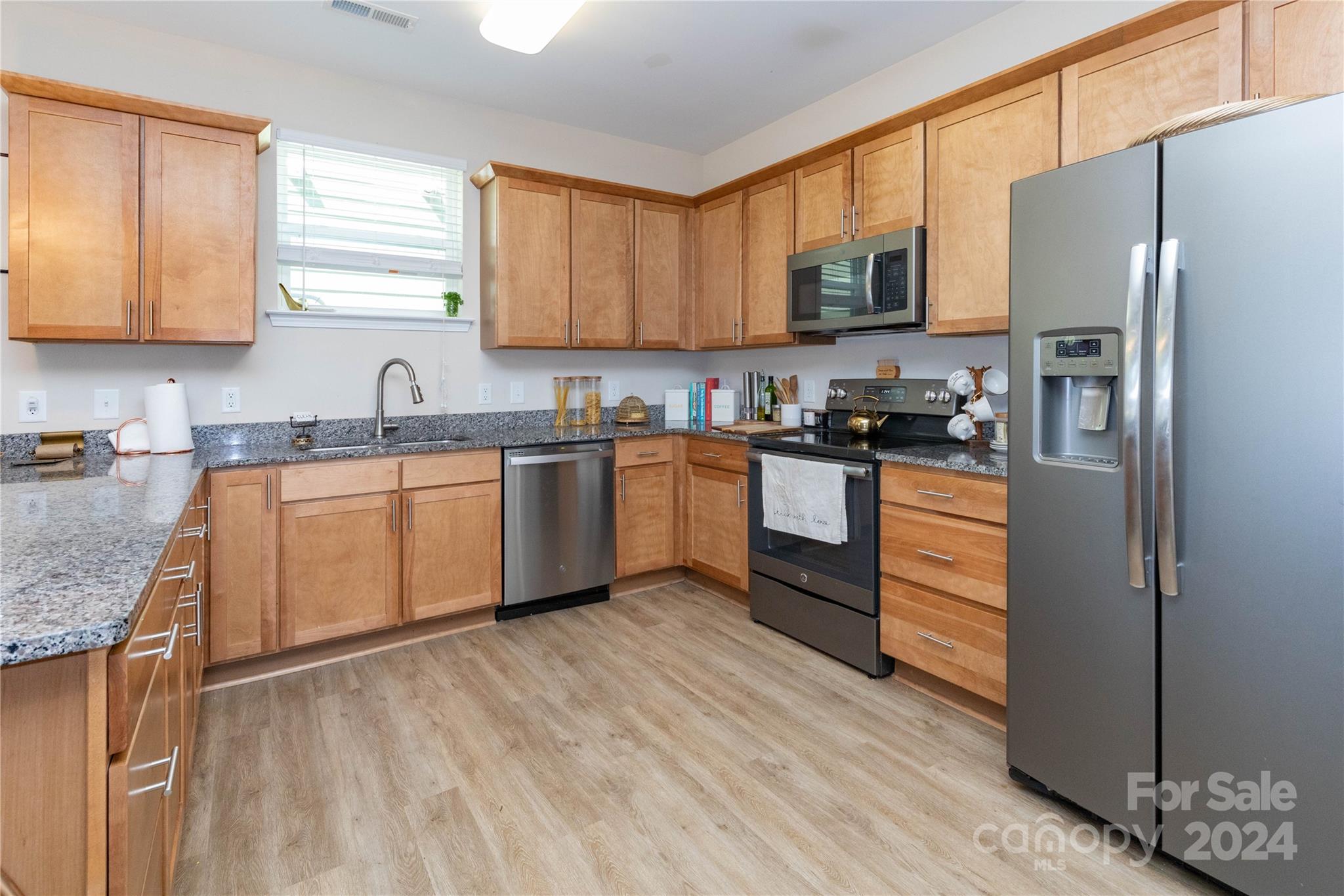 72 Shiloh Road Asheville, NC 28803 - Photo 6 of 15 a kitchen with stainless steel appliances granite countertop a stove a sink dishwasher a refrigerator and a microwave oven with wooden floor