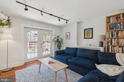 a living room with furniture a bookshelf and a window