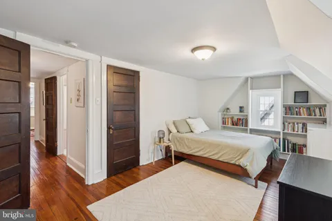 a bedroom with a bed and a wooden floor