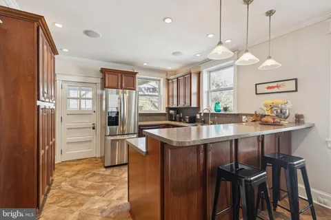 a kitchen with stainless steel appliances granite countertop a sink a stove and a refrigerator