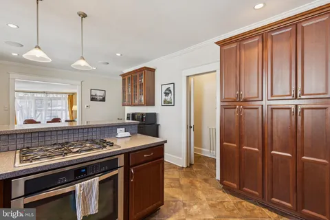 a kitchen with stainless steel appliances granite countertop a stove a refrigerator and a sink with wooden floor