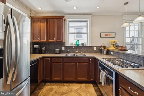 a kitchen with stainless steel appliances granite countertop a stove a refrigerator and a sink
