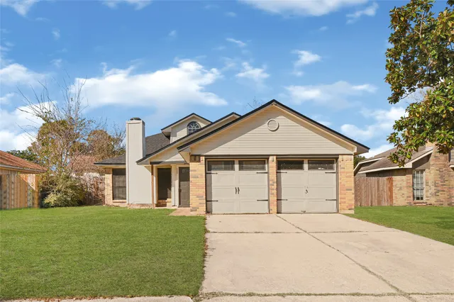 a view of a white house with a yard and plants