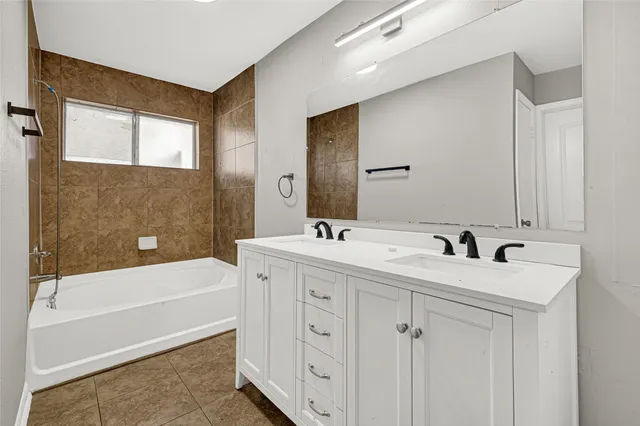 a bathroom with a double vanity sink and a bathtub